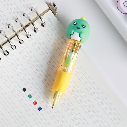 Mini-Stift mit Kopf als Dino auf einem Spiralblock, daneben Punkte in den vier Tintenfarben
