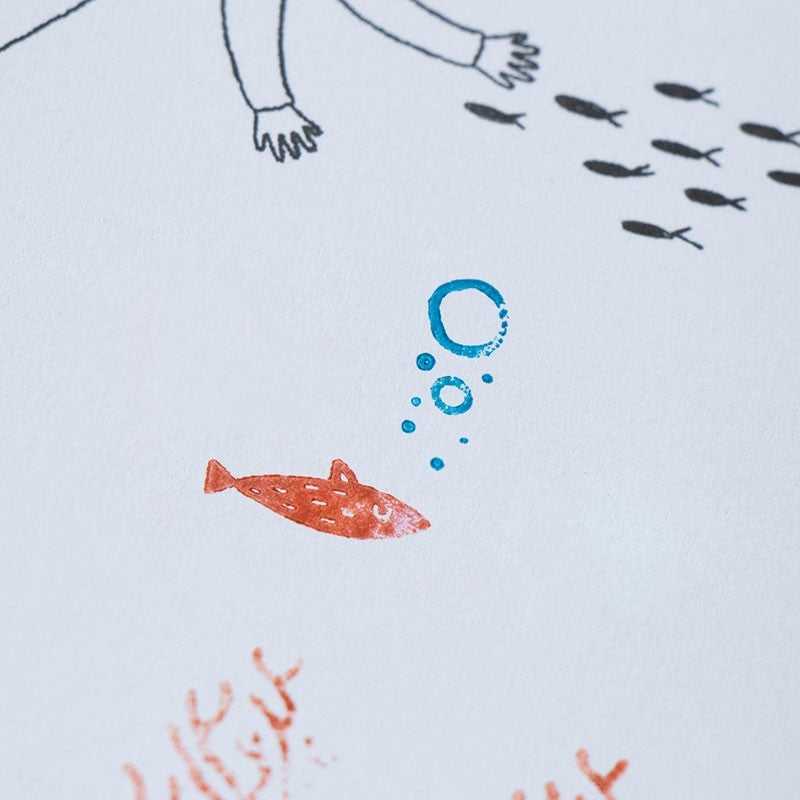 Bedruckte Beispielseite mit rotem Fisch, blauen Luftblasen und schwarzen Fischen