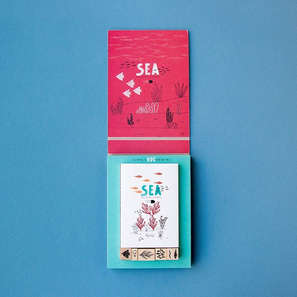 Londji Sea Calm Stamps, geöffnete Schachtel mit pinkfarbenem Deckel, Faltblättern und Holzstempeln