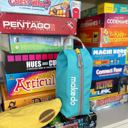 Makedo Tool-Case in Türkis steht im Regal neben Gesellschaftsspielen