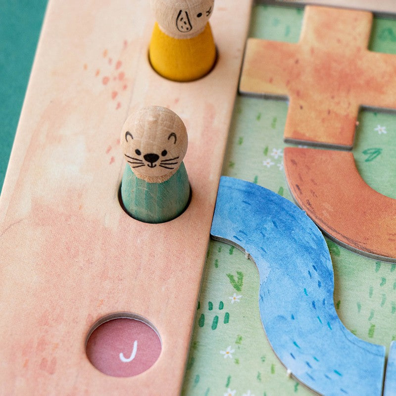 Londji Best Friends: Otter-Holzfigur auf dem Spielbrett neben blauen und orangen Wegteilen