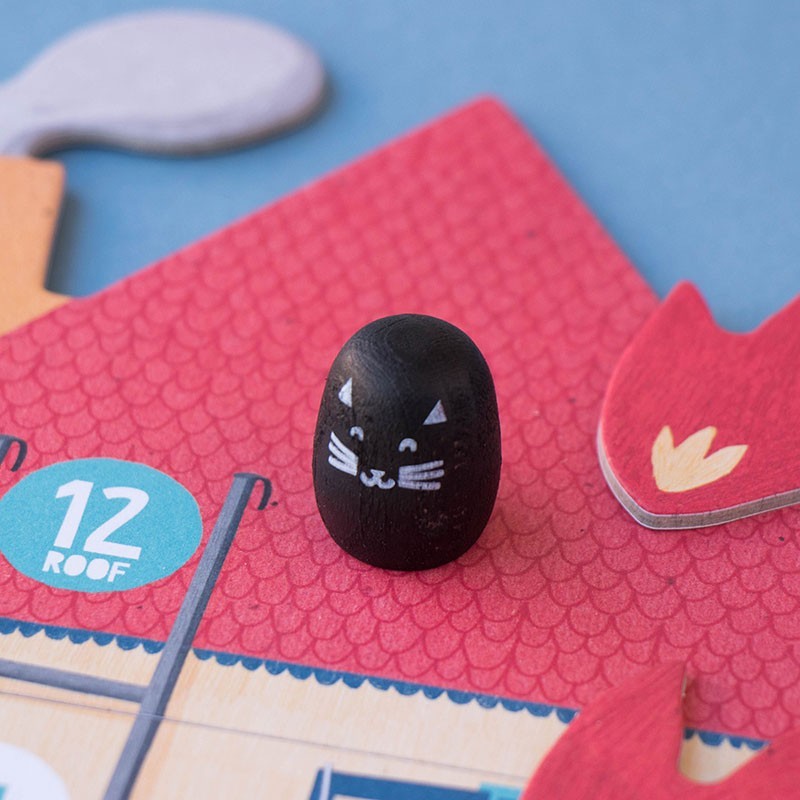Schwarze Holzspielerfigur mit Katzengesicht und weißen Schnurrhaaren auf rotem Spielplan von Londji Save the Cat