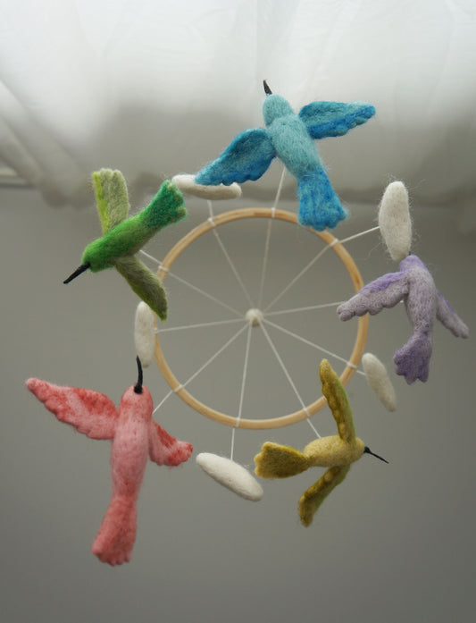 Gamcha Filz-Mobile mit acht bunten Kolibris in Blau, Grün, Rosa, Violett, Weiß und Gelbtönen an einem Holzring hängend