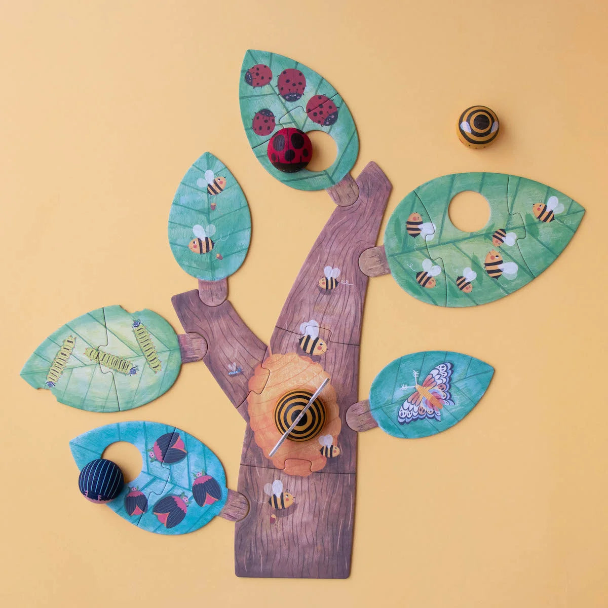 Londji Bzzz: gelegtes Baum-Puzzle mit türkisen und rosa Blättern, darauf Holzinsekten