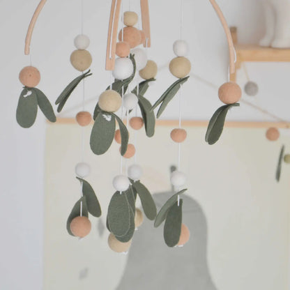 Blätter-Mobile von CALM for dreamers im Kinderzimmer, Filzkugeln und -blätter an zwei Holzbögen