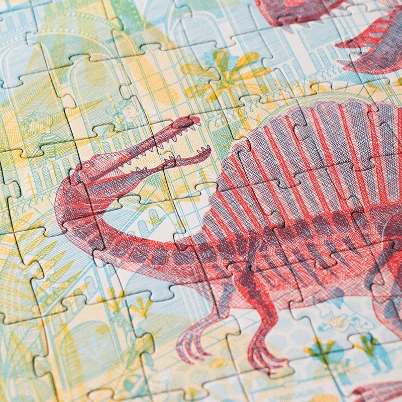 Londji Dinosaurier-Puzzle teilweise zusammengesetzt, rote Dinos und gelbe Palmen auf illustriertem Untergrund