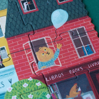 Londji Look Up Puzzle, Figur im Fenster eines roten Backsteinhauses hält einen hellblauen Ballon