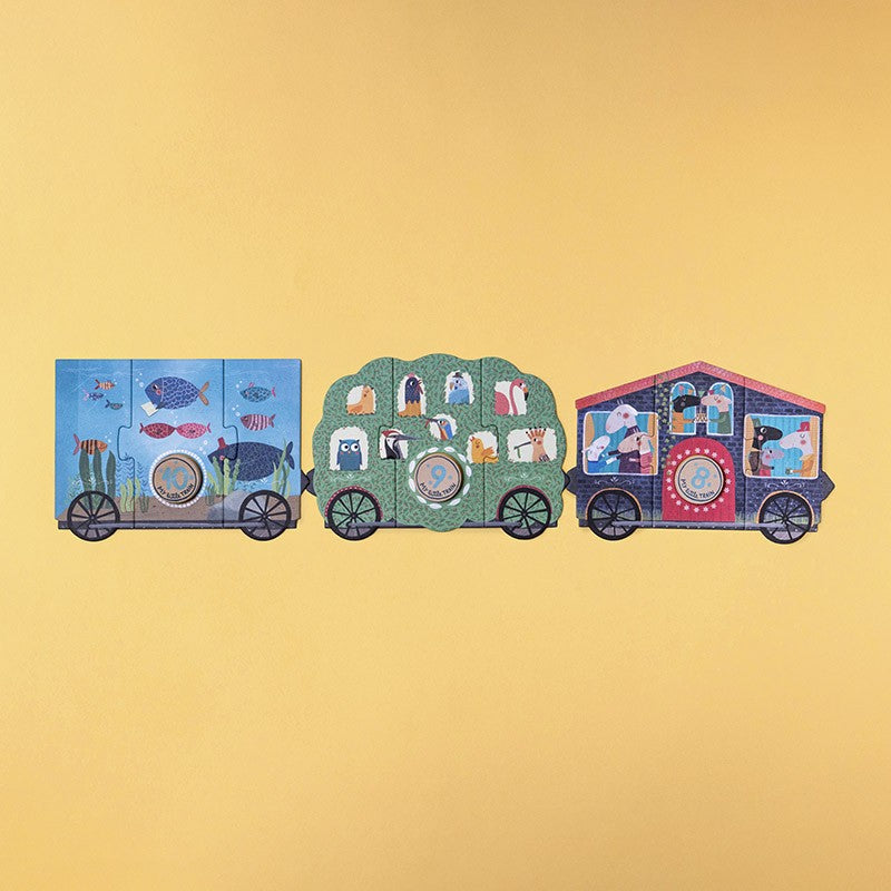 Londji My Little Train Puzzle, drei bunte Zugwagen nebeneinander auf gelbem Grund, jeder mit verschiedenen Motiven