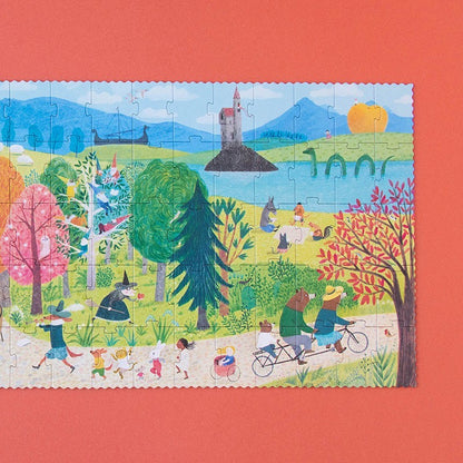Londji Once Upon a Time Puzzle mit Märchenszenerie, Wald, See, Schloss und spielenden Menschen auf rotem Grund
