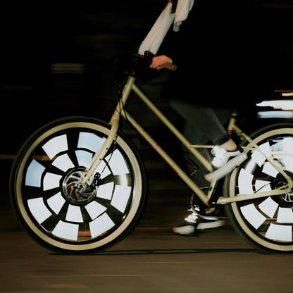 Fahrrad in Fahrt bei Nacht, die Rainette Speichenreflektoren an beiden Rädern leuchten weiß auf