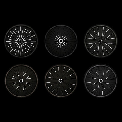 Sechs Fahrradräder bei Nacht mit unterschiedlich verteilten Rainette Speichenreflektoren, die weiß aufleuchten