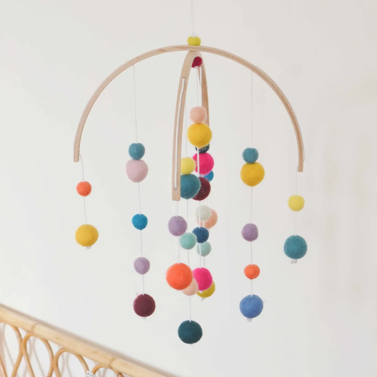 CALM for dreamers Sommer-Mobile mit bunten Filzkugeln an zwei Holzbögen vor heller Wand