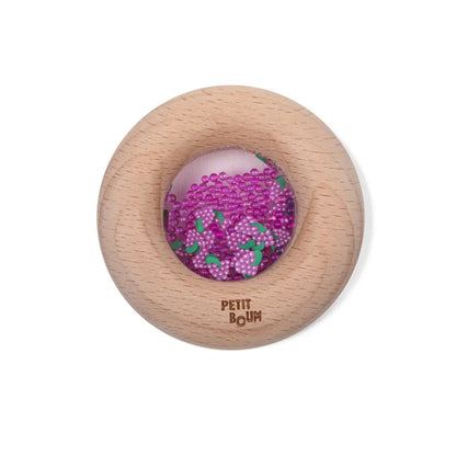 Petit Boum Sensorik-Donut aus Holz mit transparentem Fenster, darin lila und grüne Perlen, Packshot